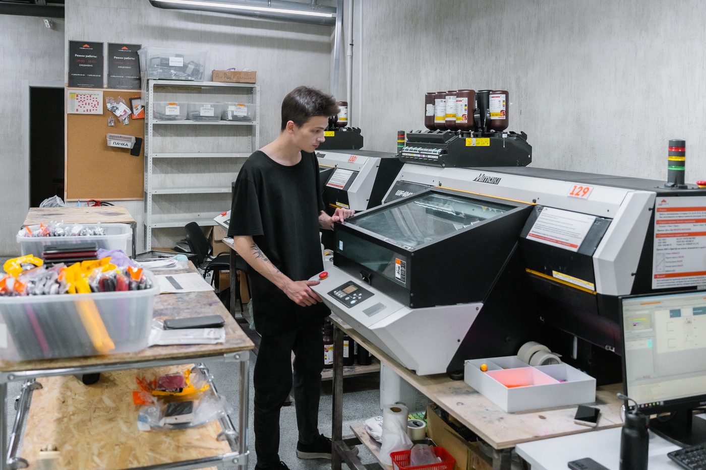 Operator running a Mimaki UJF-6042 UV flatbed printer